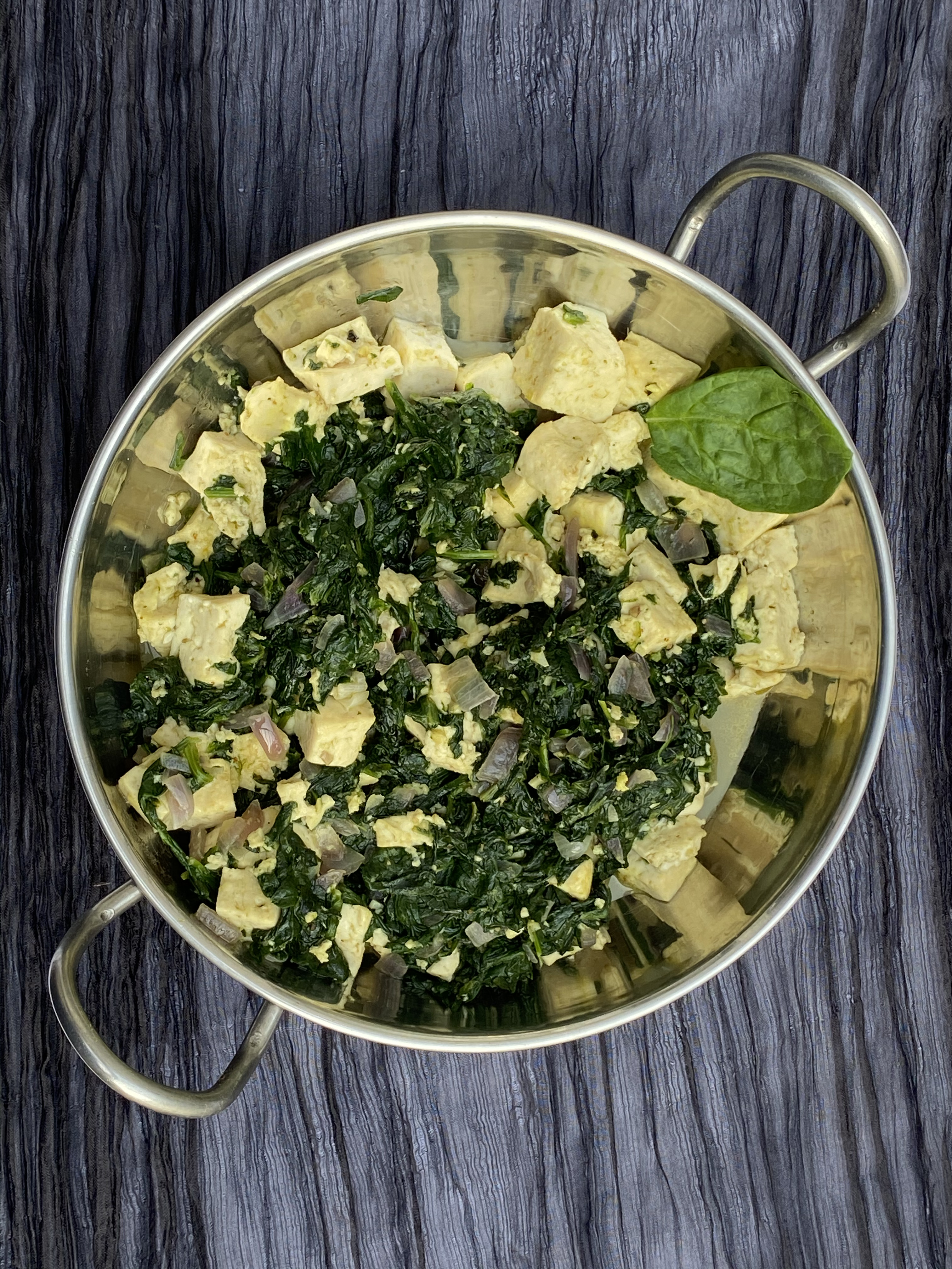 Saag Tofu served in a silver bowl