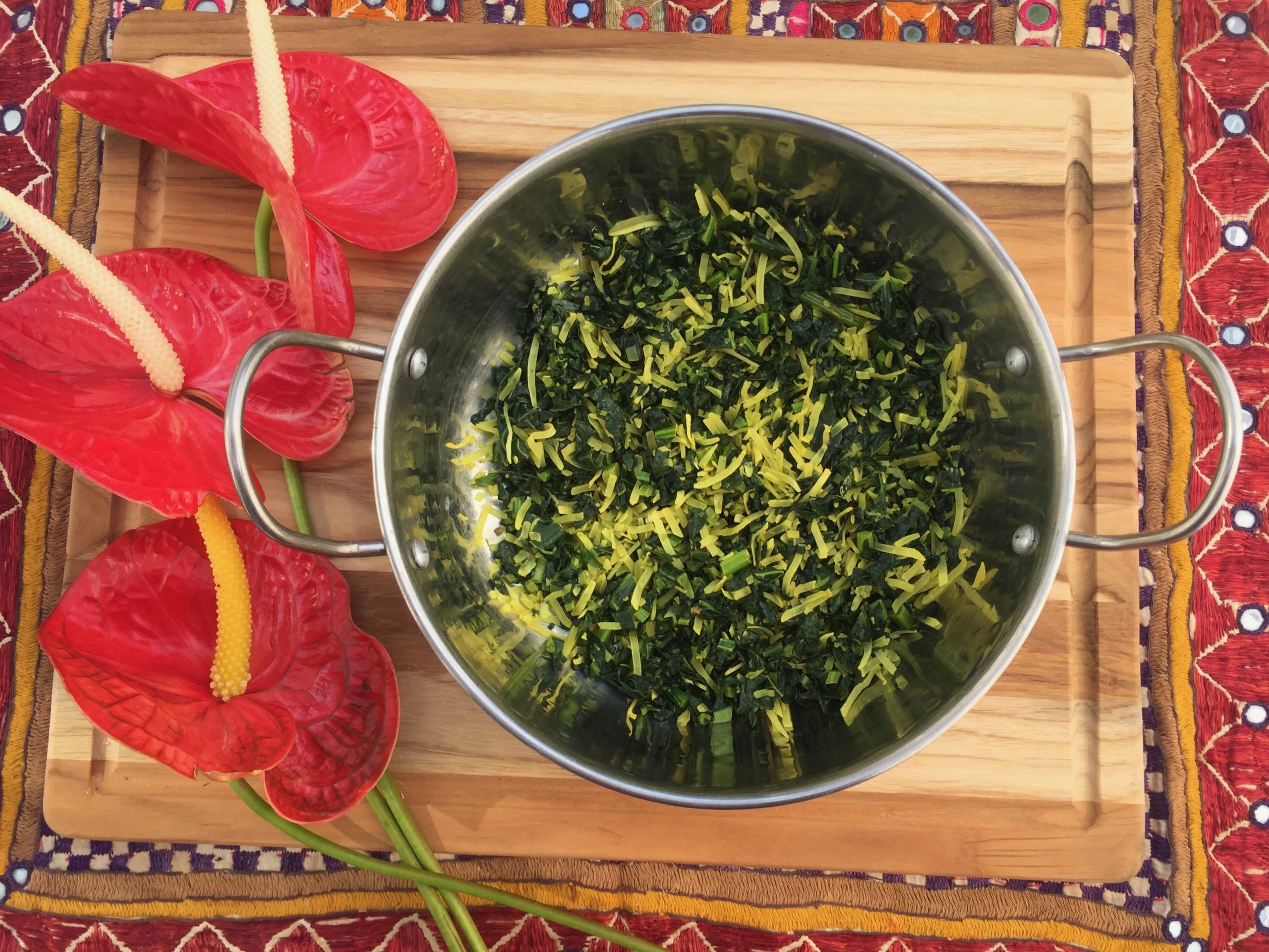 Mallung served in a silver dish. Red flowers as a decorative element.